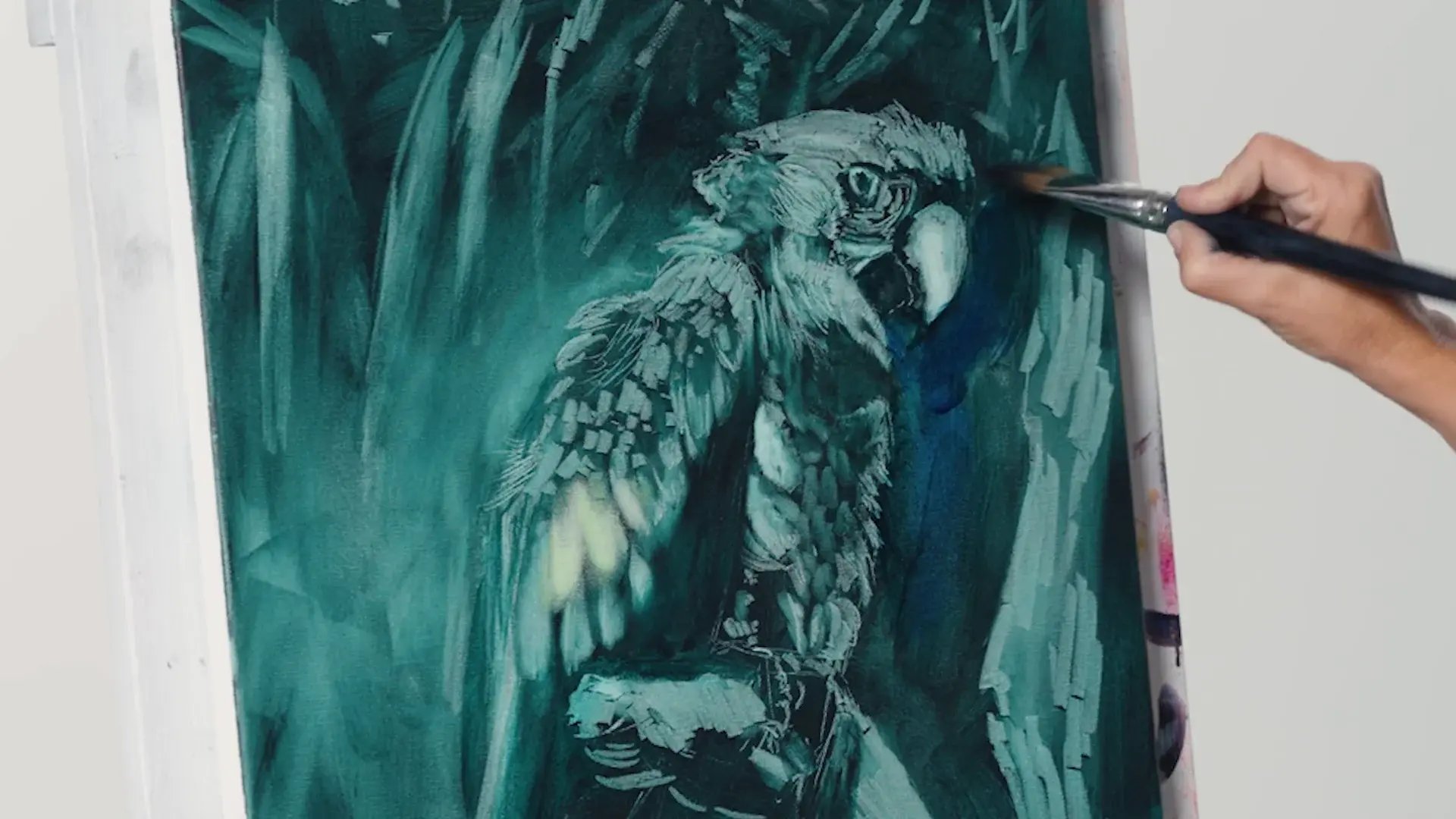 The parrot's first layer finished in teal light and dark, a brush starting the first glaze
