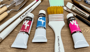 table with paint tubes blue and red with white paintbrush