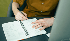 Person sketching in notebook