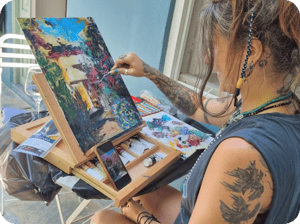 Woman painting landscape using pallet knife