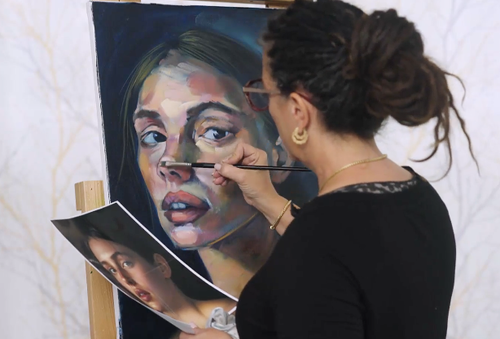 woman painign a tan portrait of a woman