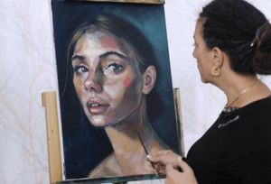 Woman painting portrait of woman