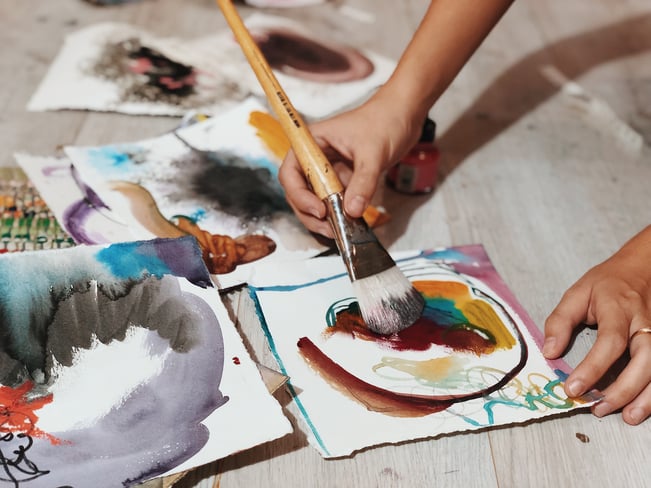 hand painting with paintbrush on paper brown orange blue