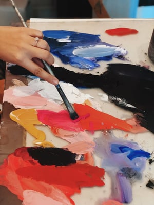 Dimitra Milan mixing paint on a glass pallet