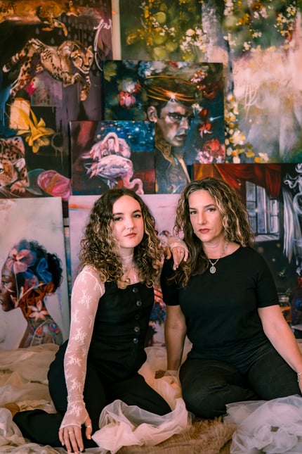 Dimitra and Elli Milan women sitting in front of art canvas