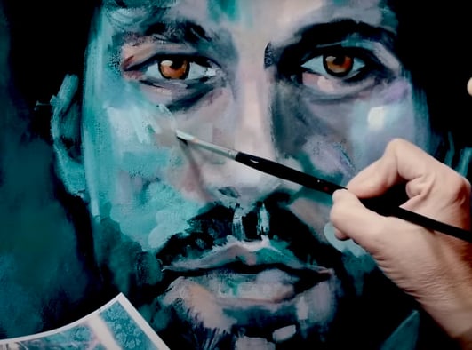 habd painting a blue and tan portrait