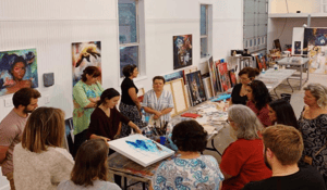group of women with people standing around artwork