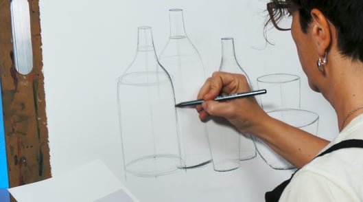 Artist draing bottles on paper