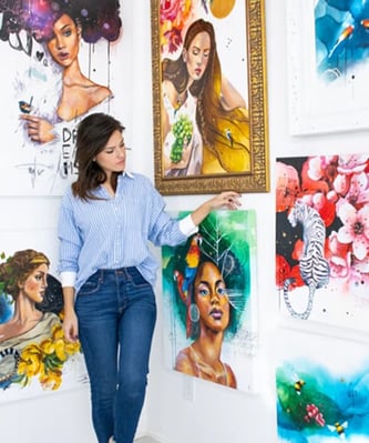 Rita Woman standing infornt of colorful paintings