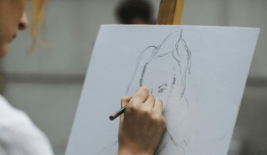 hand sketching a woman's face on white background