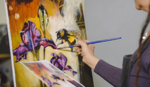 Hand painting wiht paint brush pink flowers and yellow bumble bee