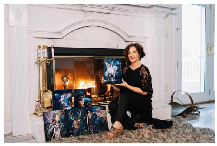 Artist holding horse art blue and black in front of fire