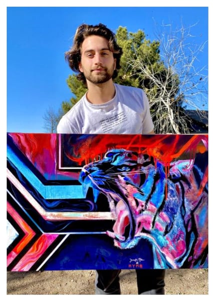 Photo caption: A photo of Jake Dunn with a piece of art that he created in the Mastery Program. 