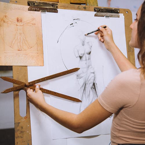 woman in front of drawing board using proportional tool