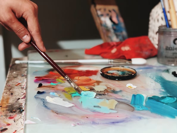 Palette Closeup Oils hand with brown paintbrush