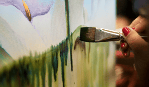 paint brush painting green paint on canvas