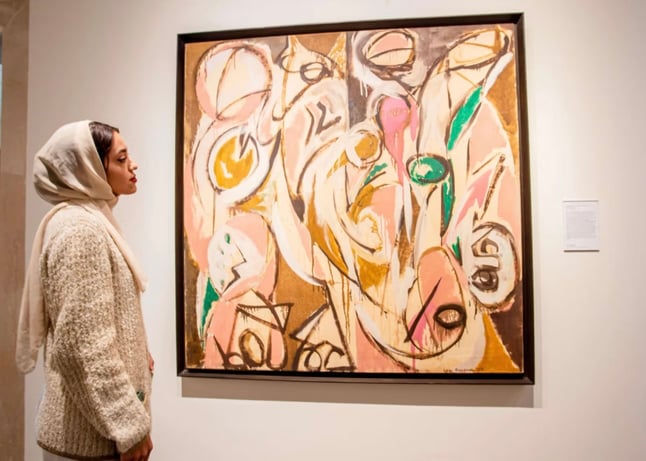 Re-Echo Lee Krasner’s Earth Green series, abstract painitng yellow green pink white with female in cream standing in fron of painting