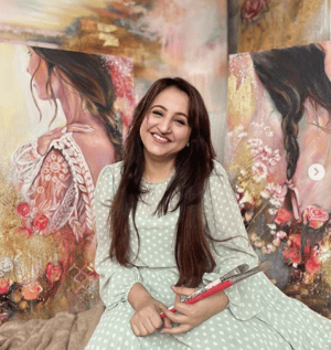 Woman sitting in front of portrait painting pink cream 