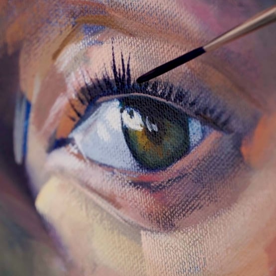 painting with brush painting black eye lashes on green eyeball