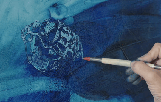 Hand using subtraction tool to make highlights on blue canvas