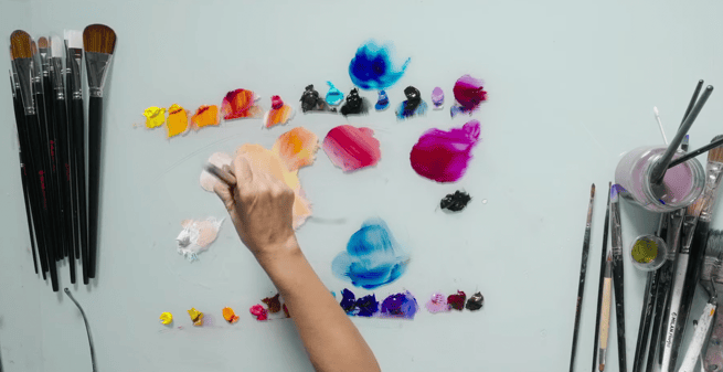 pallet with mixed colors pink blue paintbrushes