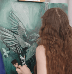 Woman making a green bird underpainting 