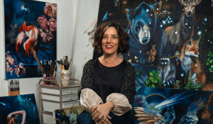 Elli sitting in front of animal paintings 