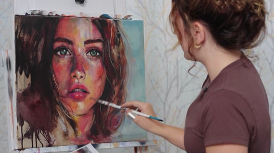 Woman in brown shirt painting portrait of woman with green eyes brown hair