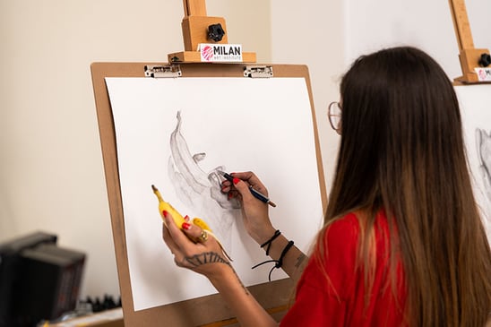 Woman drawing a banana on an easel with drawing board
