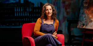Elli Milan sitting in red chair