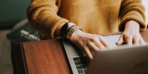 Woman building art website yellow sweater