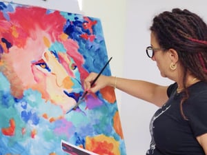 Woman in black painting on canvas vibrant lion red pink blue orange