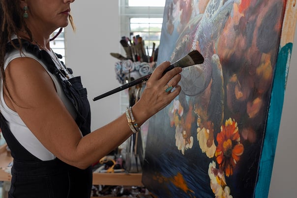 Woman painting strong bold colors with large paintbrush