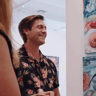 man standing in art gallery talking