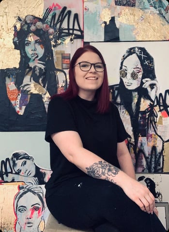 Woman smiling in fron of pop art portraits