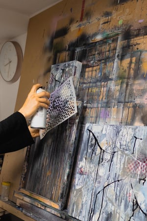 Women using Spray painting with stencil on a canvas