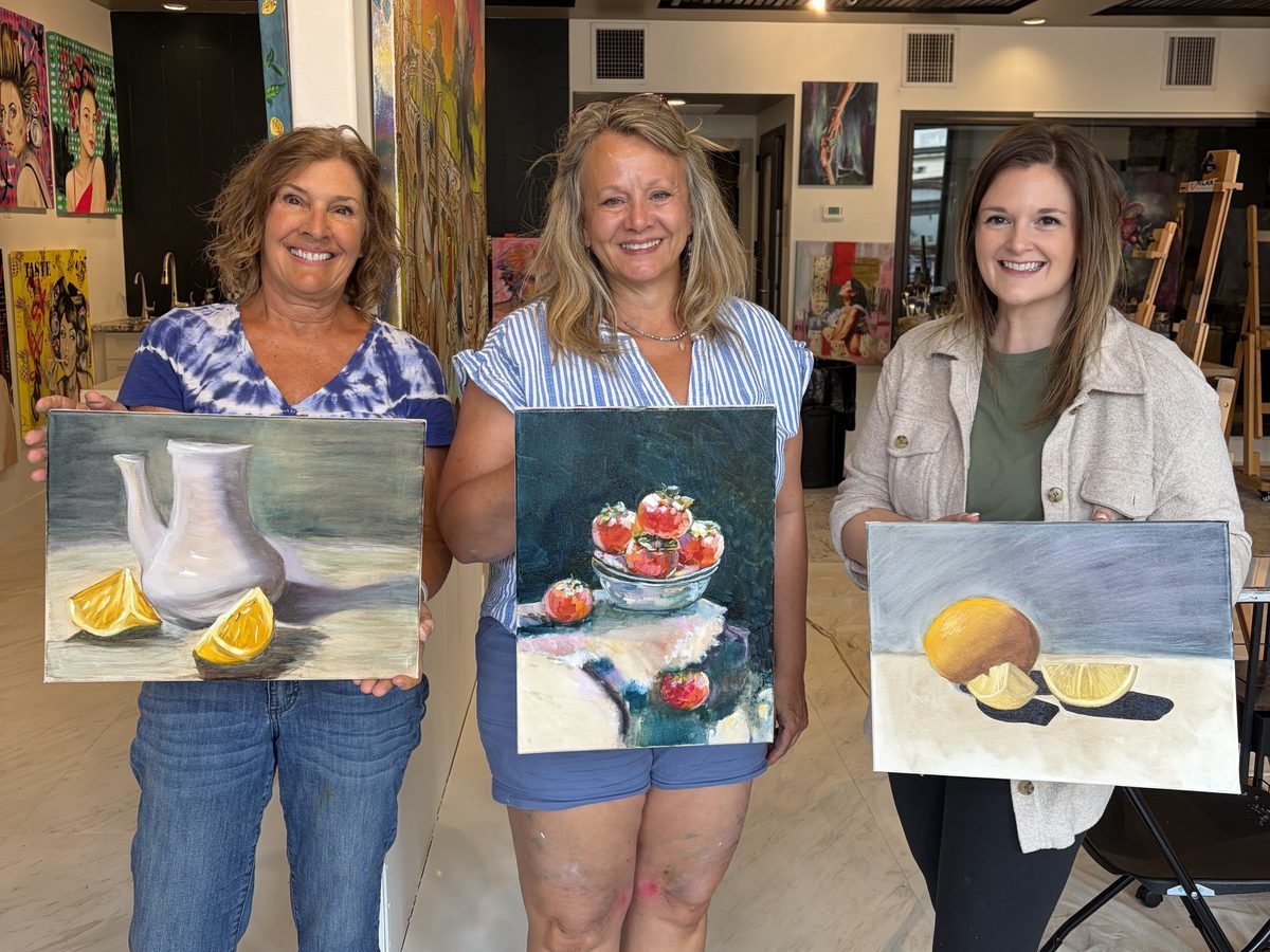 Three students holding the still life paintings they finished in one class at the Milan Art Gallery, Sarasota