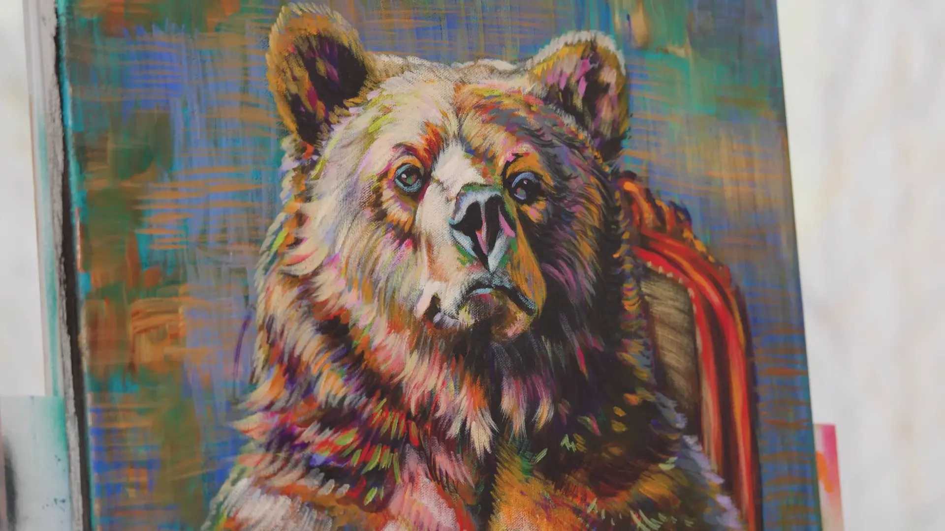 The finished bear's face in cream, rust, violet and green strokes