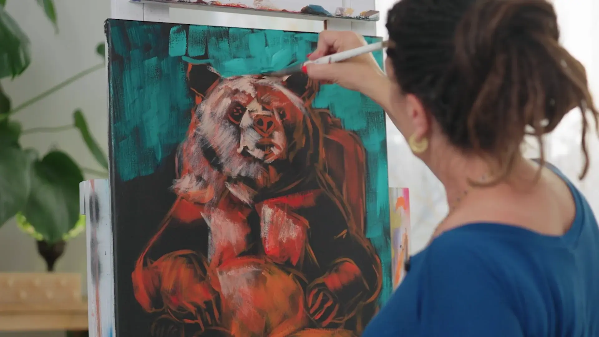 A turquoise background going in around the red-orange bear