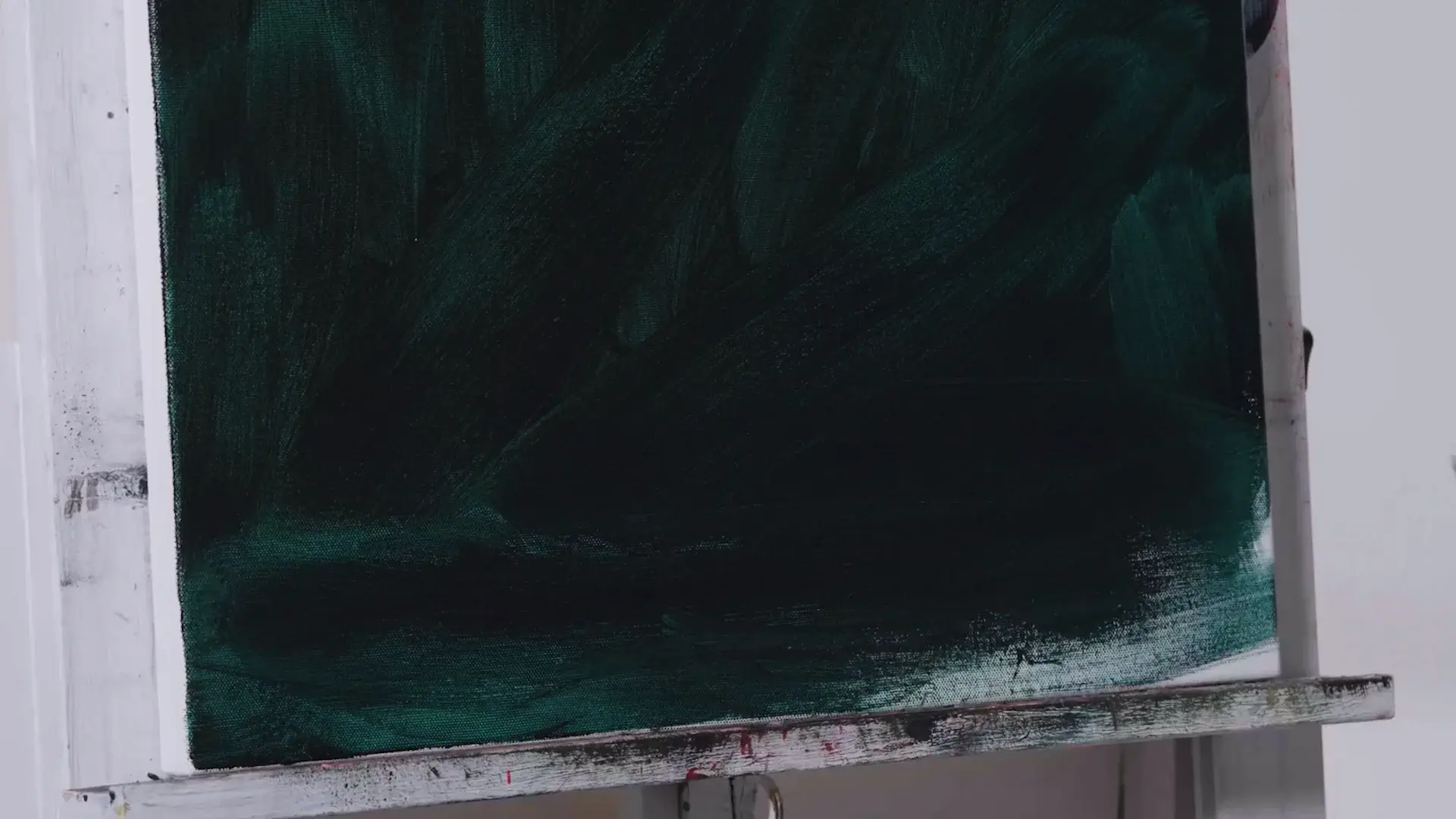 A thin dark green wash brushed across the whole canvas