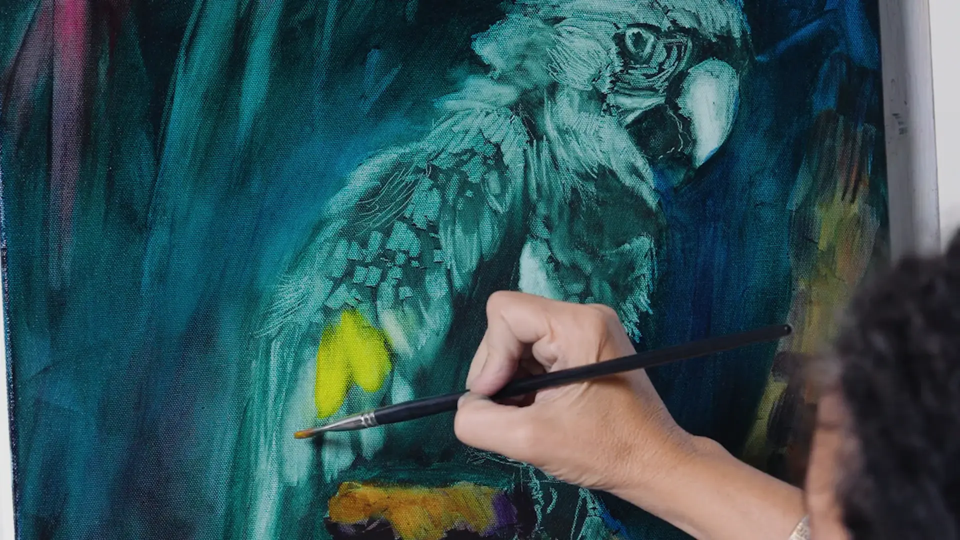 A yellow-green transparent glaze going onto the teal wing