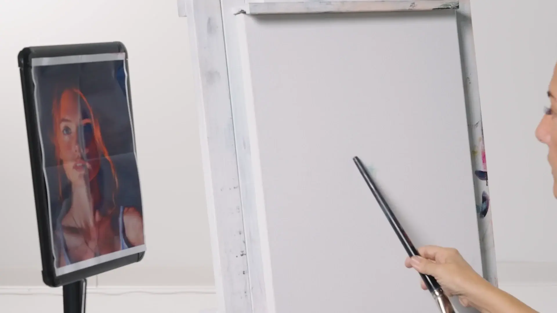 A blank white canvas beside the reference portrait on a tablet