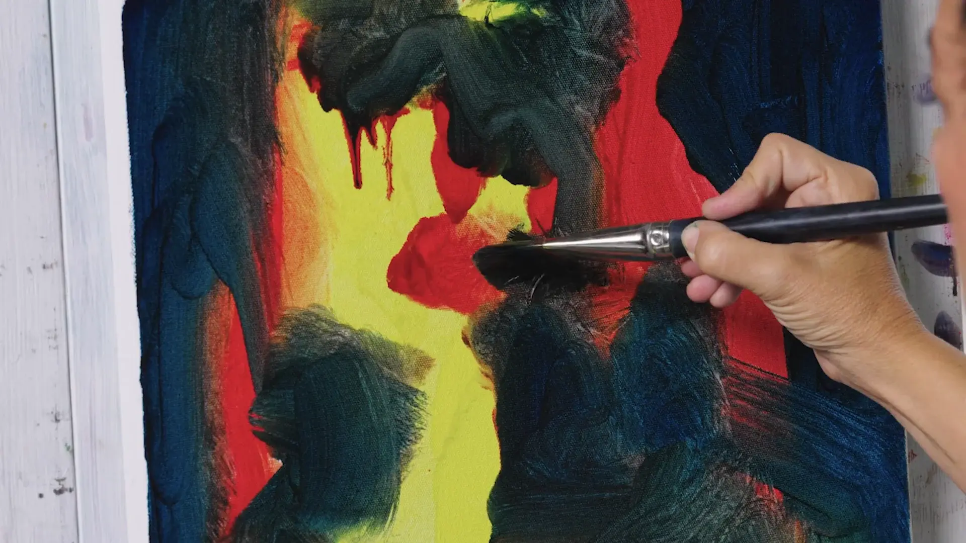 Dark blue-green paint dragged over the red and yellow block-in