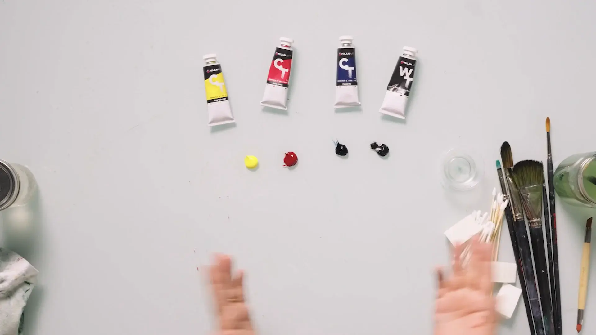 Four oil paint tubes with a dab of each color below them
