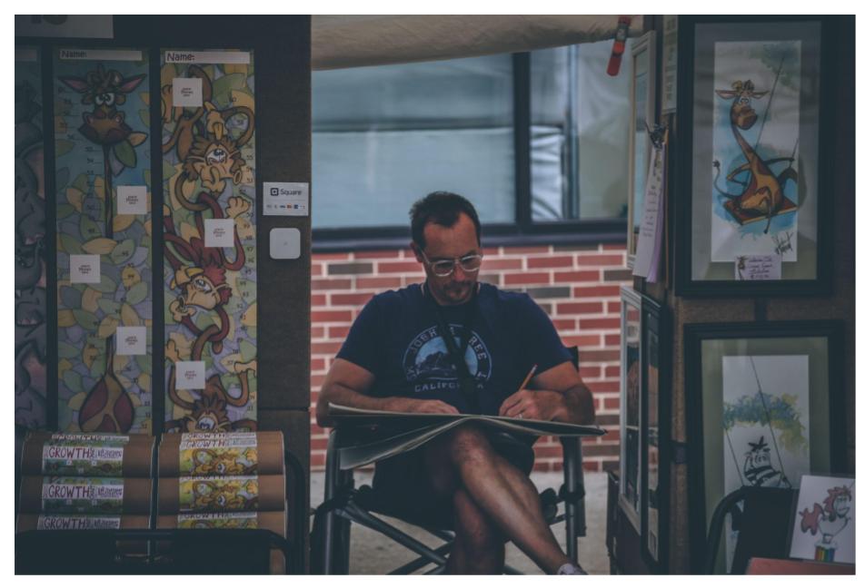 Man sititng in chair drawing