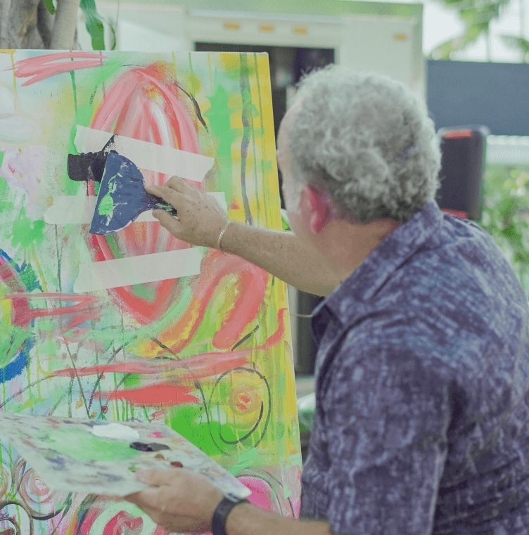 Older man painting on canvas