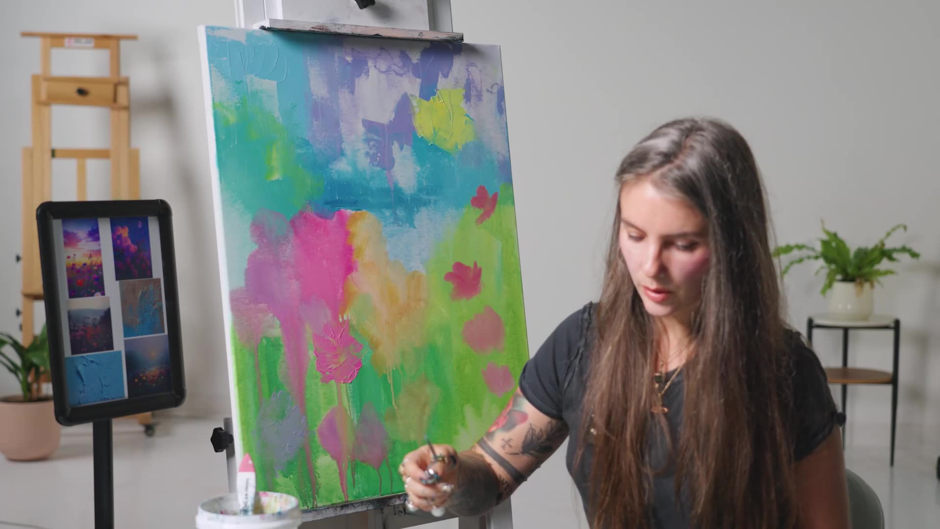 Woman painting on canvas on easel neon foundation 