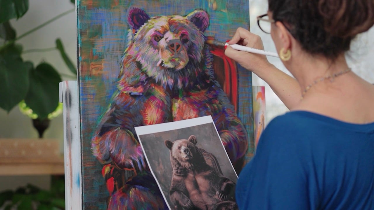 Woman painting a bear on a canvas 