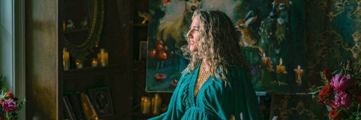 Woman in green dress standing in front of window 