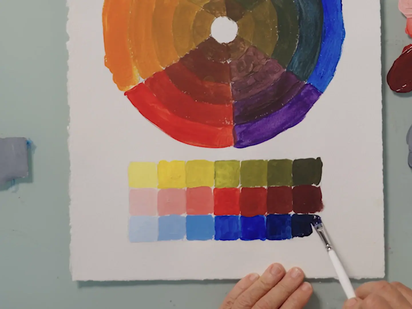 A painted color wheel with rows of tints and shades below it, from lesson 8